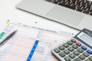 確定申告書と電卓とノートパソコン