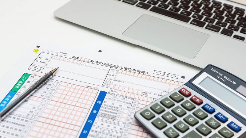 確定申告書と電卓とノートパソコン